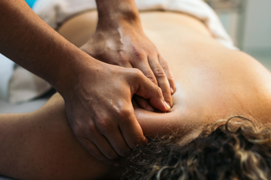 Close-up of hands giving a woman a back massage, massage therapy for back pain treatment in Maple Ridge. 