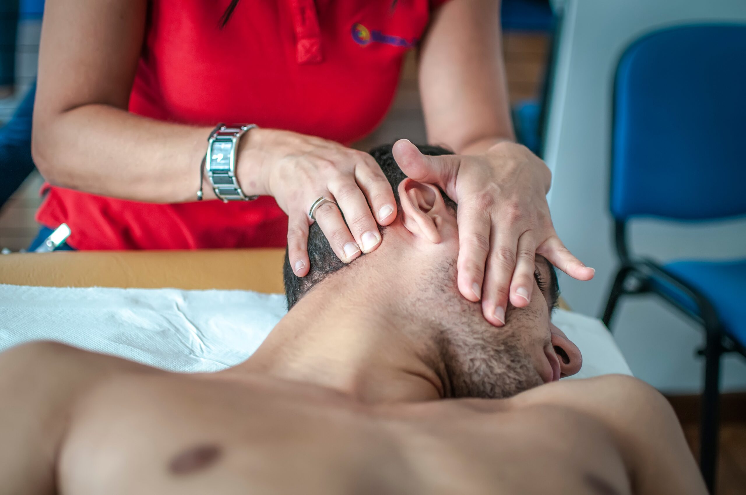A man receives a facial and neck massage for jaw pain relief.
