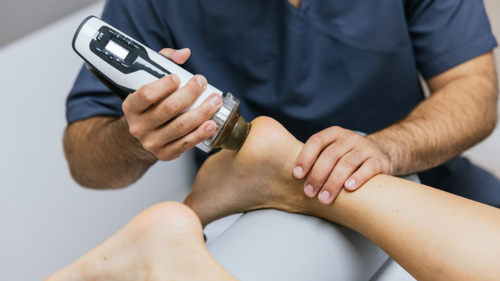A client gets shockwave therapy in their feet to support healing.